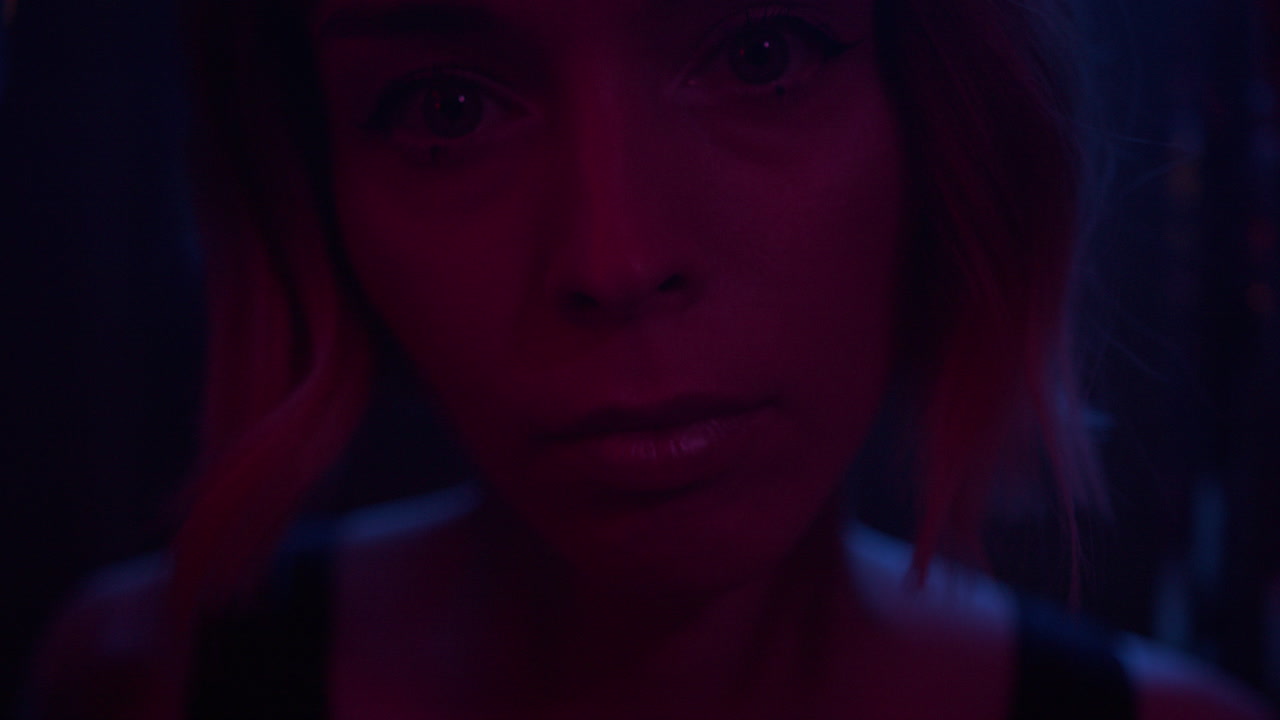 A young woman walks through glittering curtain