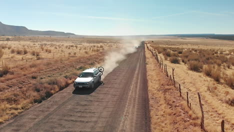 low aerial as silver station wagon with bike rack passes underneath