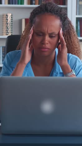 woman working on laptop, looking stressed