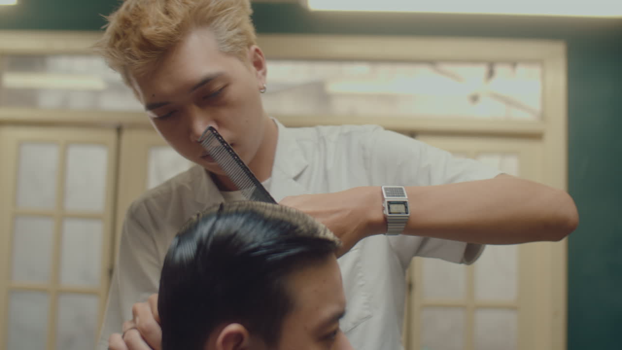 Asian Barber Doing Haircut for a Client in Barbershop