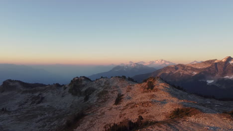 dramatic mount brew aerial drone footage on peak revealing diverse hazy mountain landscape with sun flare in canada british columbia 4k