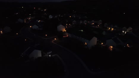 aerial approaching shot of quiet american housing area at night. lighting lantern and lights of houses. suburb district with single family homes and apartments in pa, united states. peaceful scene.