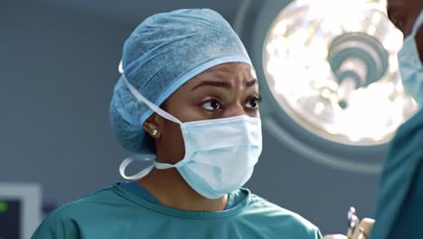a skilled surgeon concentrates deeply on a complex procedure, wearing a surgical mask and cap while navigating a tense environment in the operating room with medical staff.