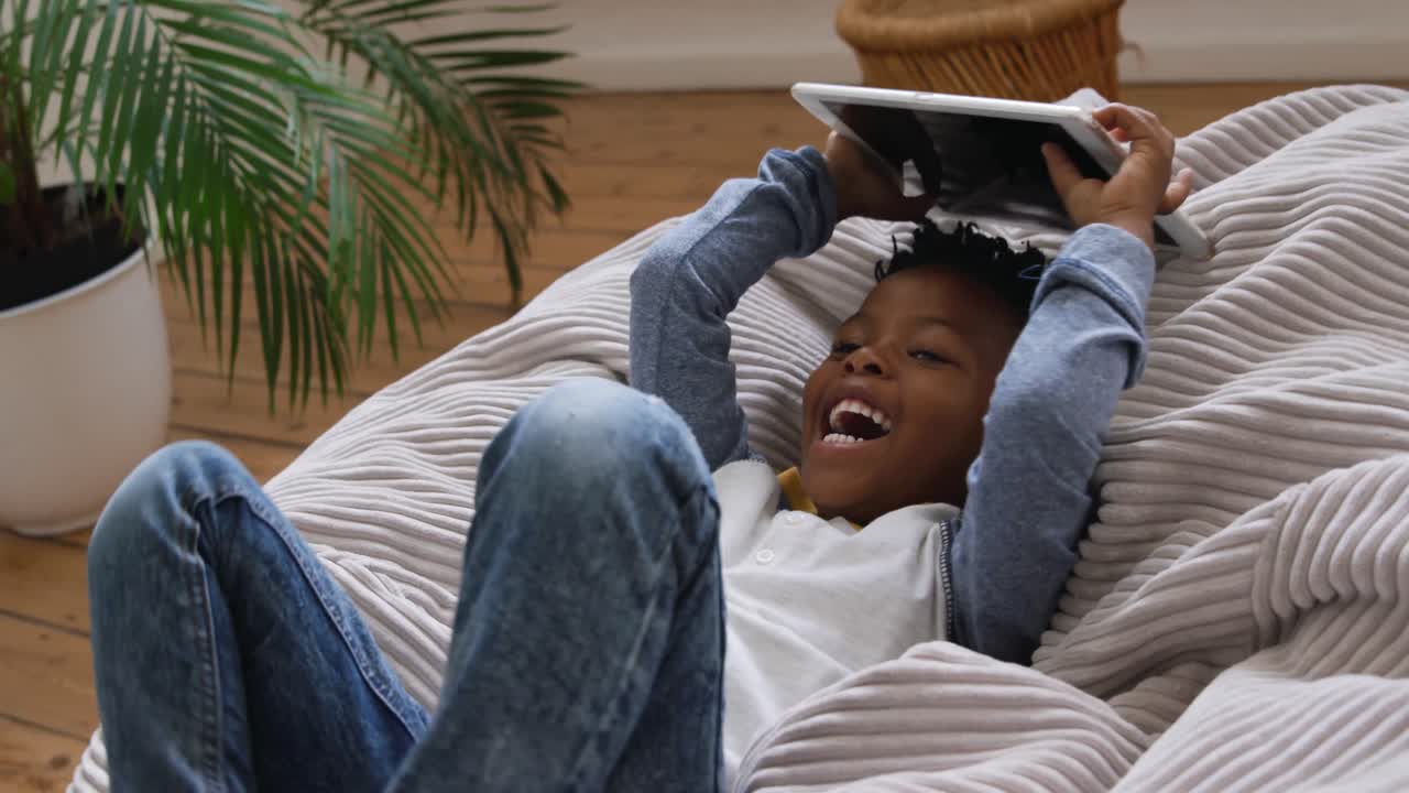 Boy using tablet computer at home