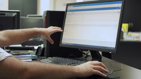 Side-view-medium-shot-of-experienced-engineers-looking-at-computer-screen-and-explaining-his-ideas-to-colleague