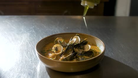 oil gets added on a plate with mussels