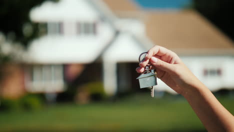 una mano con llaves por casa suburbana