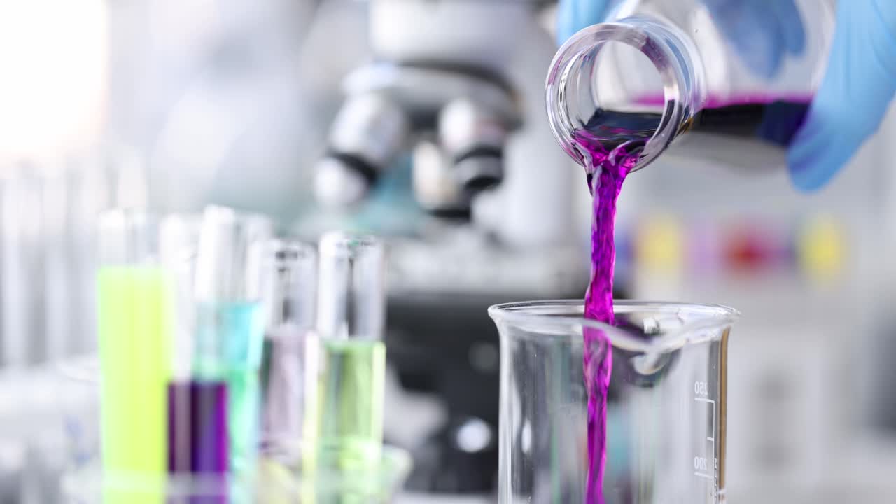 Chimico versa liquido rosa in una boccetta in laboratorio, video 4K.
