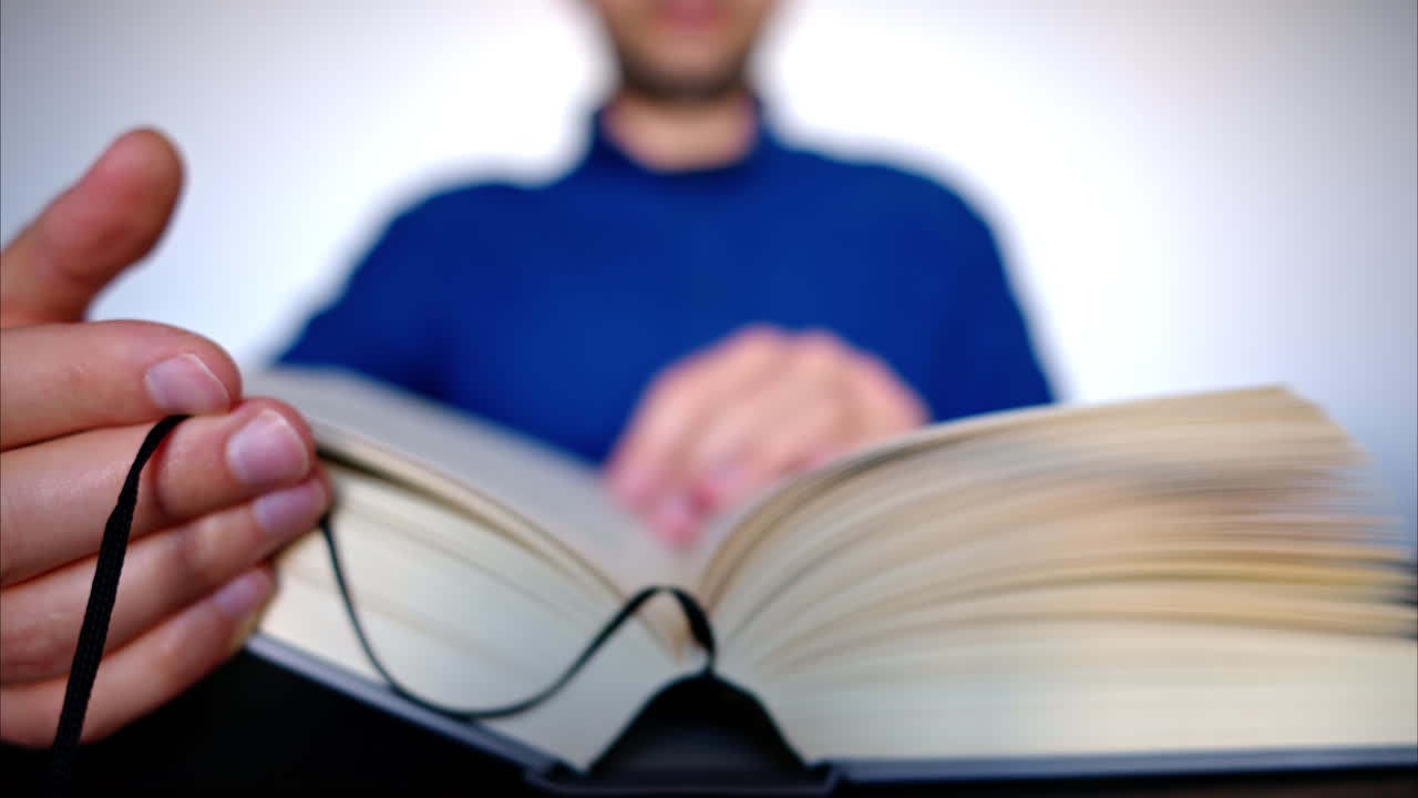 Close-up of a man leafing through a big book