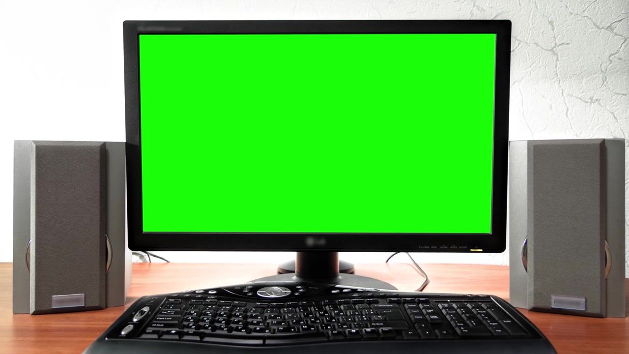 Dataskjerm med grønn skjerm står på et skrivebord på et kontor timelapse hyperlapse fremoverbevegelse. Utforming av arbeidsplass med grå lydhøyttalere og svart tastatur