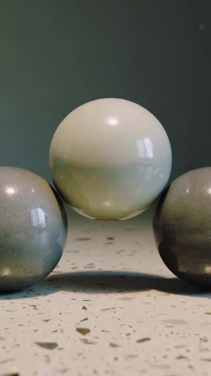 Vertical video: Shifting camera showing three spheres on speckled counter framing pale sphere