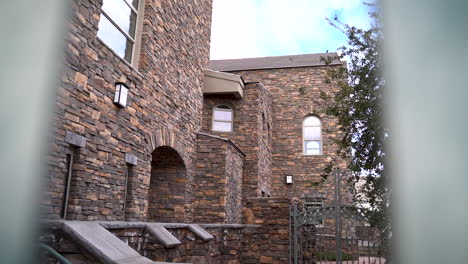 looking through fence of old castle or mansion with brick and stone