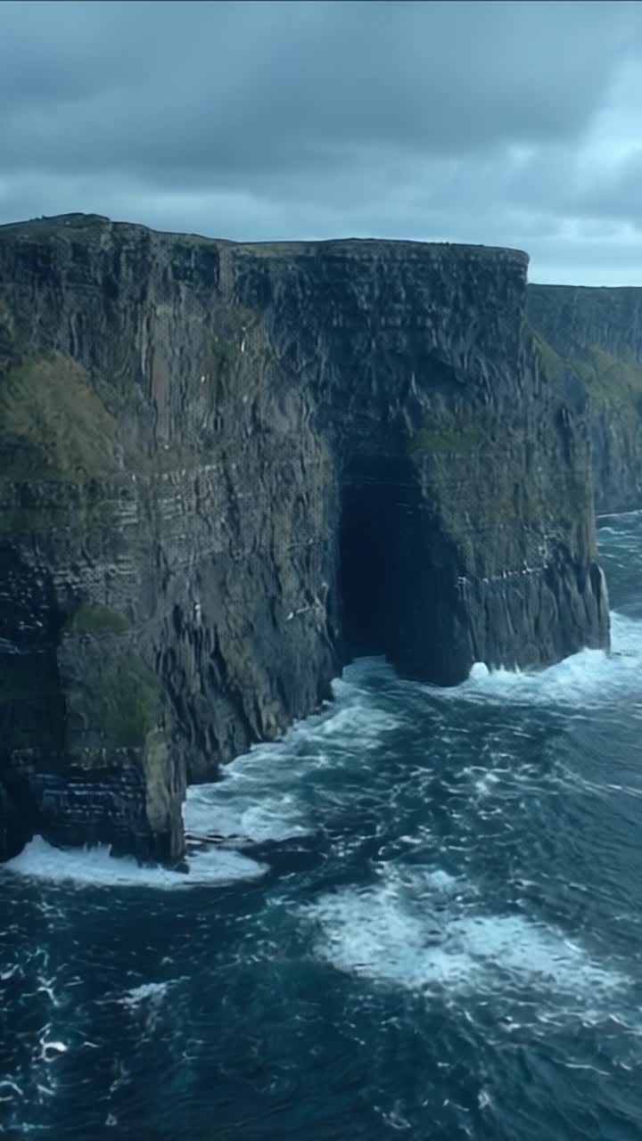 A Majestic Coastal Scene: Striking Cliffs Meet Turbulent Ocean Waves Under a Gloomy Sky