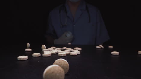 el trabajador médico vierte píldoras antivirales en la superficie negra