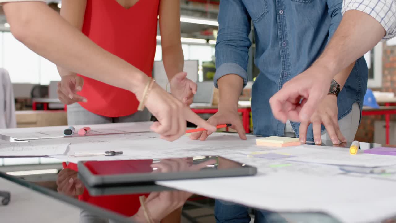 sección media de un equipo de diversos arquitectos discutiendo sobre un plan en la oficina