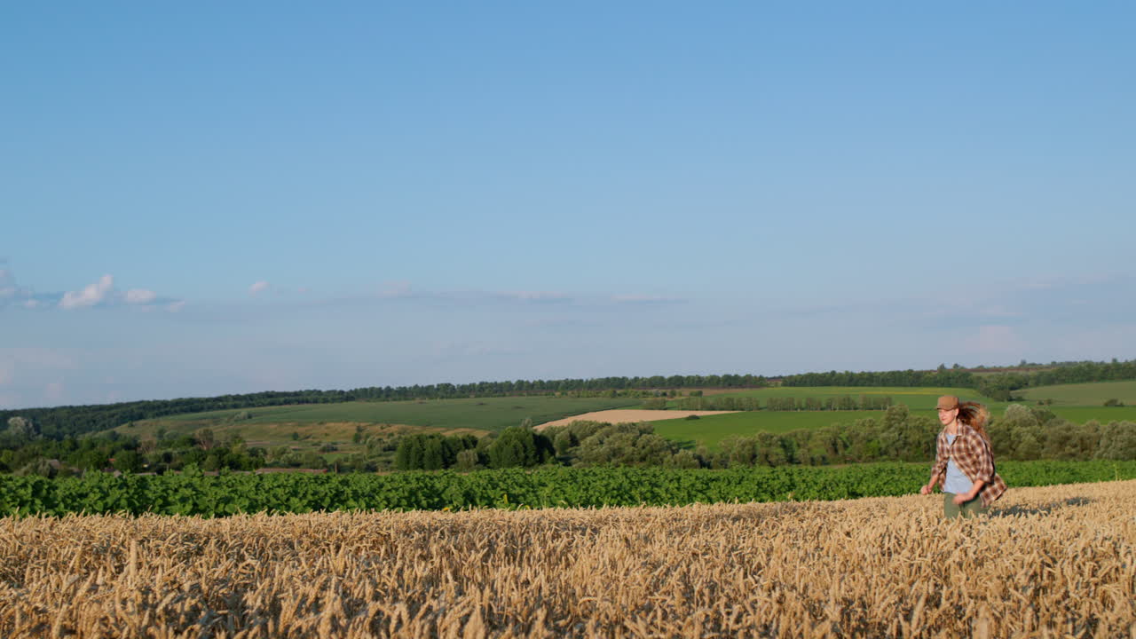 счастливая девочка-подросток бежит по живописному пшеничному полю.