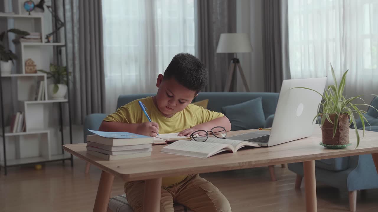 아이가 집에서 숙제를 하고 있습니다.