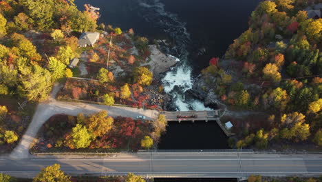 Beautiful-Canadian-water-flows-through-colorful-autumn-fall-trees-during-golden-hour-with-rapids-into-the-next-river