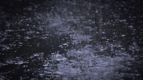 heavy rain shower downpour cloudburst rainfall behind the glass.