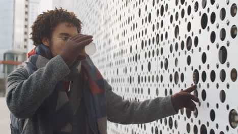young man enjoying a drink outside in the city