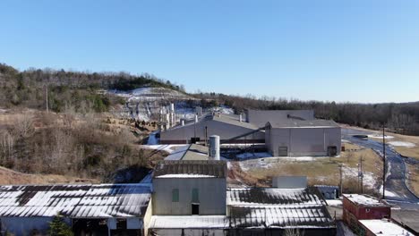 Aerial-Drone-Footage-Dollying-Towards-an-Abandoned-Brick-Factory-on-the-Edge-of-a-Quarry-and-a-Forest