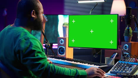 Produzent-Komponiert-Musik-Mit-Elektronischen-Keyboardnoten-Und-Greenscreen-Anzeige