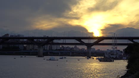 subway train crossing cheongdam bridge over hangang river with fiery sunset in the sky in seoul, south korea