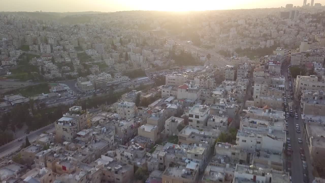 clip aéreo de drones de la hermosa madrugada en amman jordan con el sol recién salido sobre el horizonte de la ciudad dando una atmósfera pacífica con el aumento del tráfico