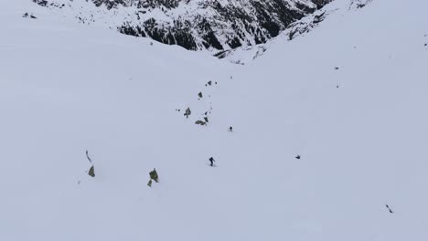 two freeride skiers going down on a steep mountain