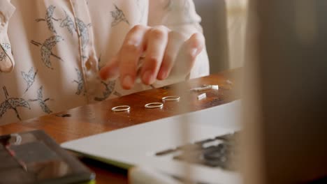 female jewelry designer examining ring in workshop 4k