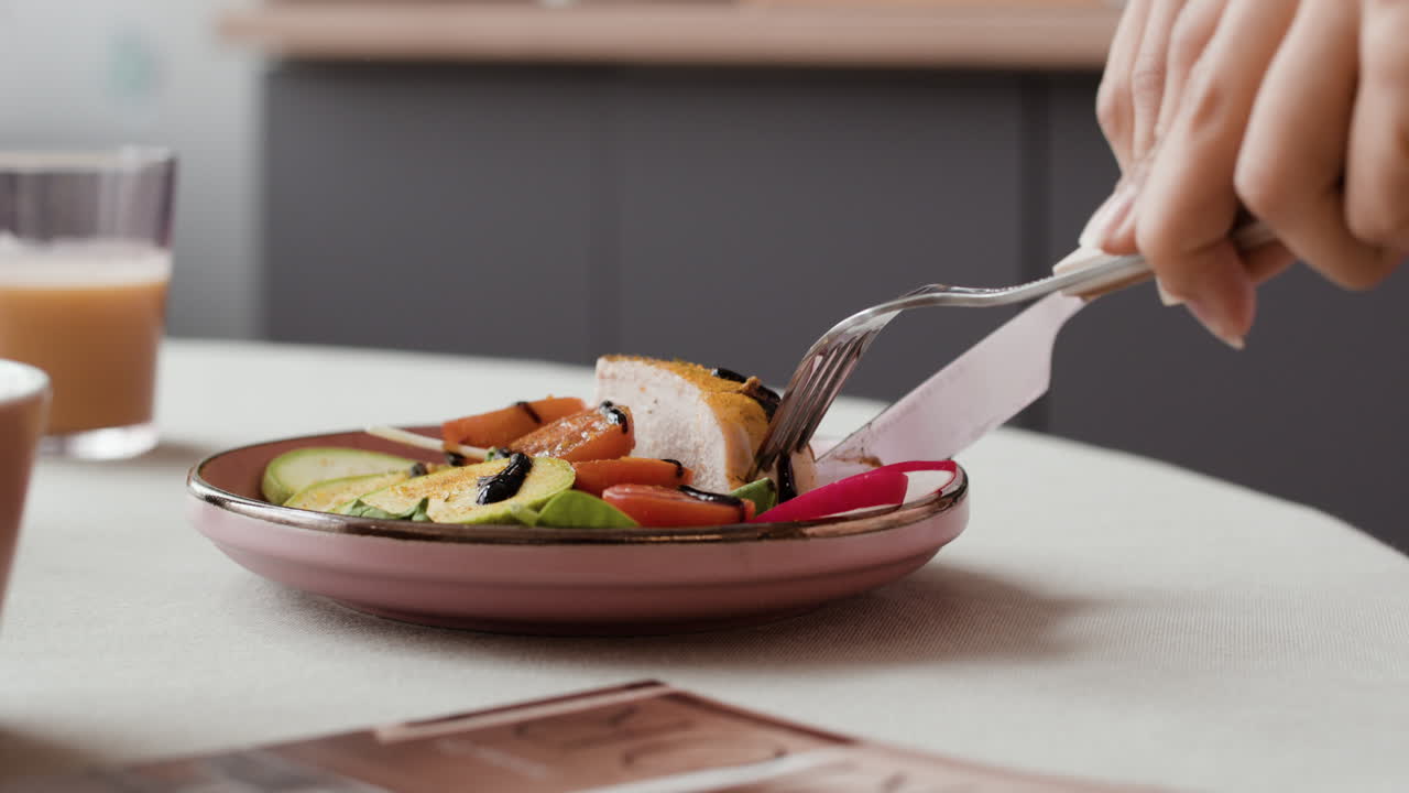 Person Cutting a Healthy Meal on a Plate