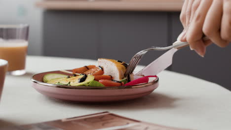 person cutting a healthy meal on a plate