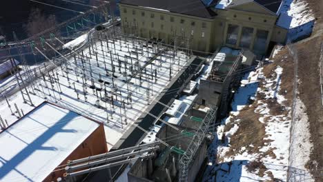 high voltage transformer and distribution station for hydroelectric powerstation nore in rodberg norway - aerial flying above network of electric cables and statkraft powerstation