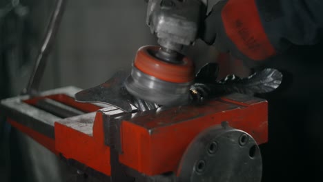 metalworker brushes steel with electric circular metal brush, metalwork in blacksmith's workshop, 4k 60p prores hq