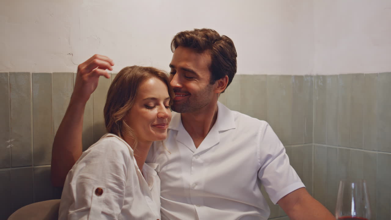 una pareja romántica besándose tiernamente en la cafetería. un hombre se une a su novia.