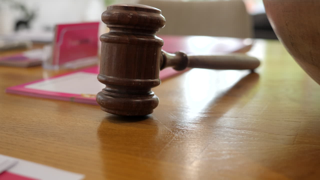 martillo o mazo de subastador sobre una mesa de madera, inclinado hacia arriba