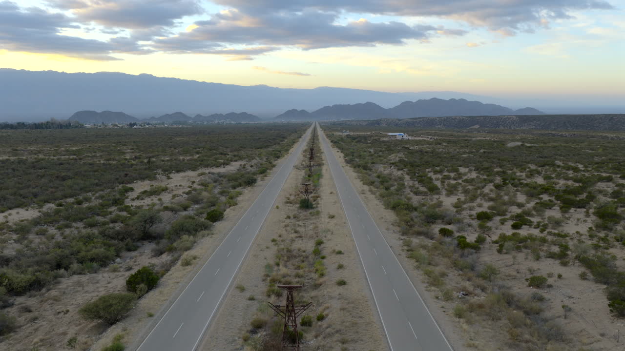 Beautiful sunrise at long straight desert highway stretching endlessly toward distant mountains, Av. la Mexicana, Chilecito, La Rioja Province, Argentina