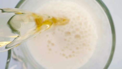 Cold-beer-being-poured-into-transparent-pitcher