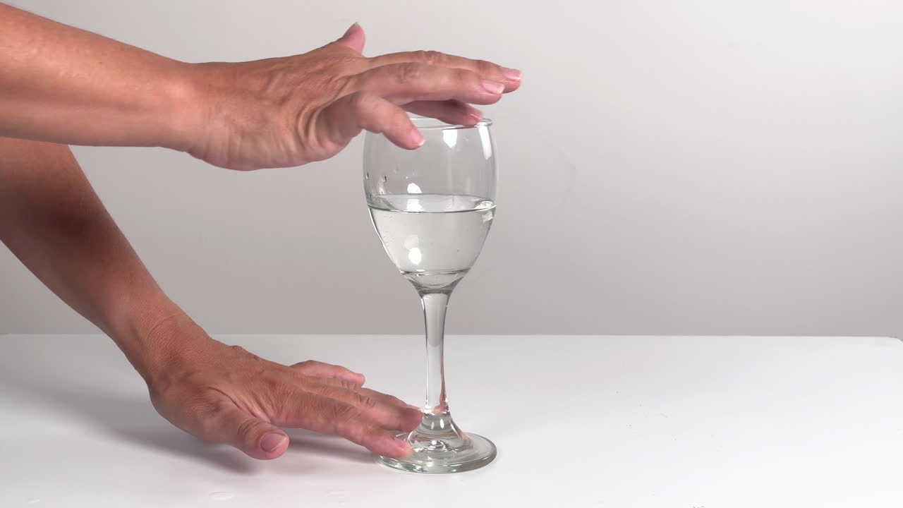 Mano umana che strofina il bordo di un bicchiere da vino per produrre un suono