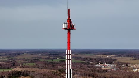 Aerial-Drone-fly-above-Latvian-isolated-countryside-landscape-with-red-tower-countryside-village