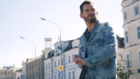 man in denim jacket on city street