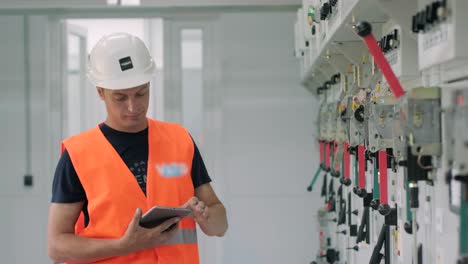 electrical engineer working check the electric current voltage and overload at front of load center cabinet or consumer unit for maintenance in main power distribution system room.