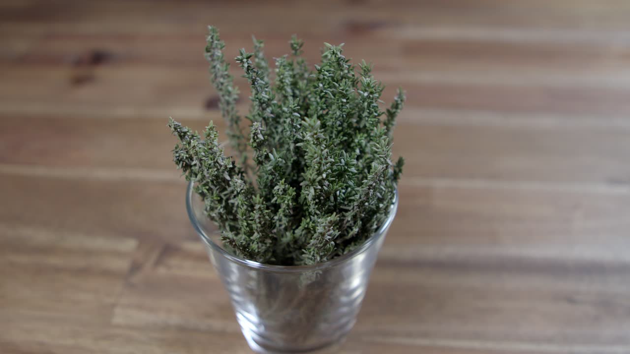 ramas de tomillo fresco en un pequeño recipiente de vidrio, ingrediente esencial para la preparación de chimichurri argentino