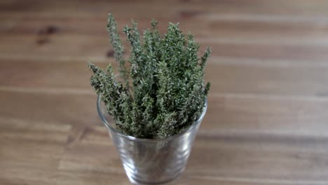 ramas de tomillo fresco en un pequeño recipiente de vidrio, ingrediente esencial para la preparación de chimichurri argentino