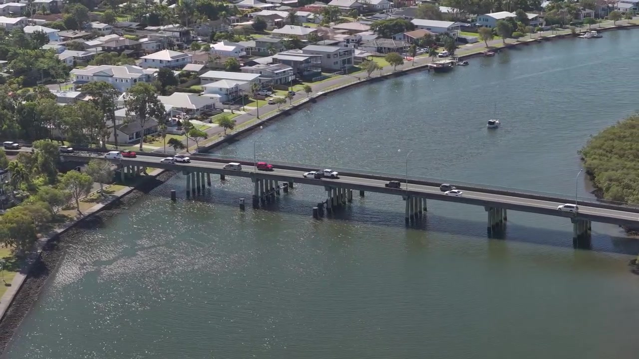Veicoli che guidano lungo un ponte a Jabiru Island, Paradise Point, QLD, Australia - Ripresa aerea con drone