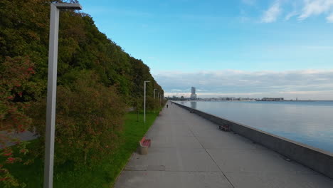 aerial dolly forward over seaside boulevard on calm day with blue skies