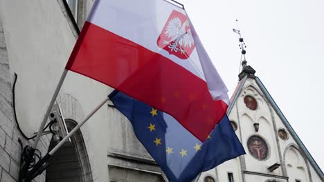 european union and poland national flags are waving because of light wind in tallinn old town