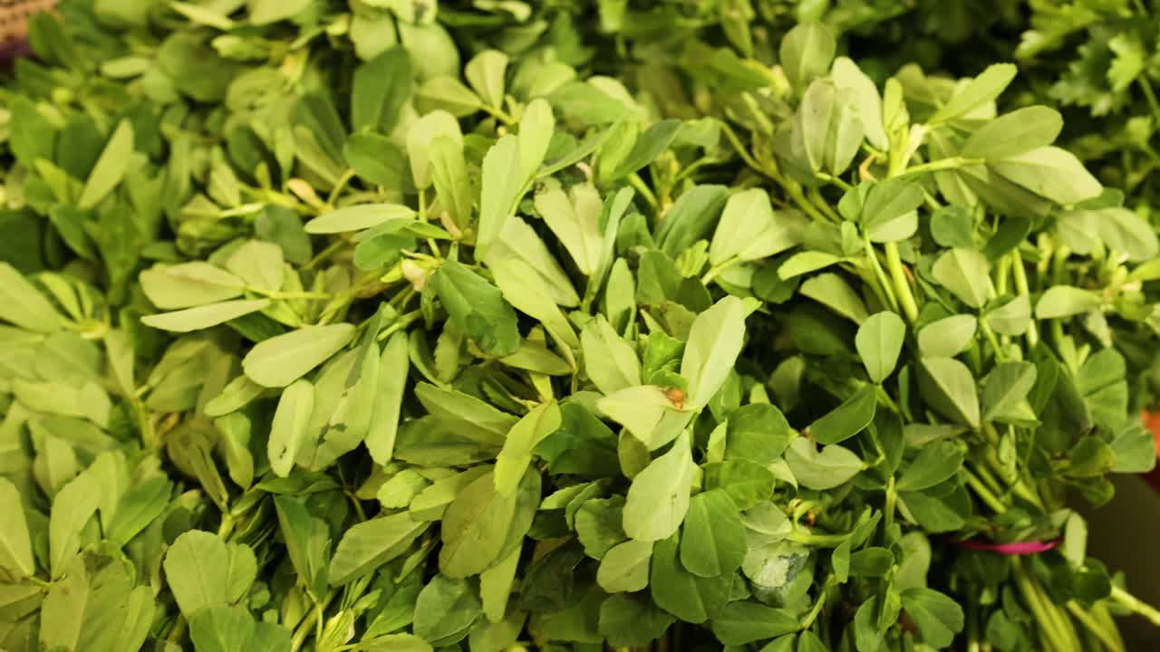 varios vegetales de hojas verdes exhibidos en un mercado