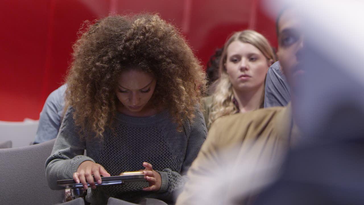 estudiante universitaria usando un teléfono inteligente en el aula, filmada en r3d