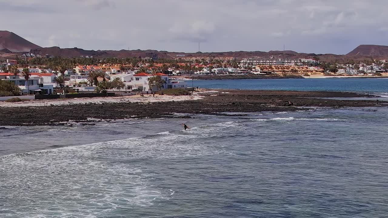 Surfista cavalca le onde vicino alla costa delle Isole Canarie in Spagna.